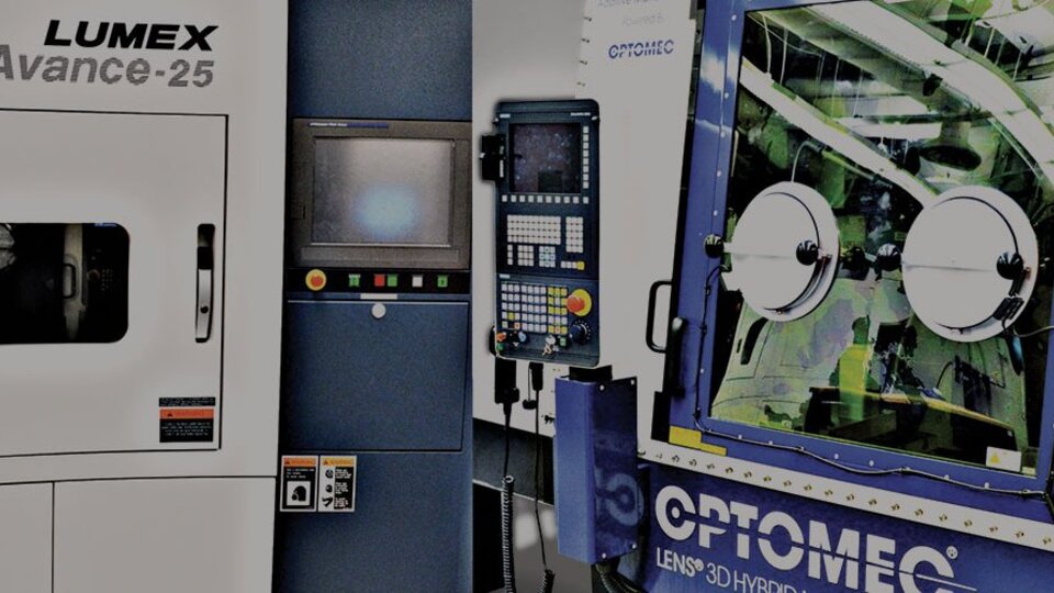 Factory machines with control panels and glass enclosures in a manufacturing setting.